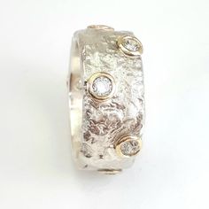 "This lovely semi-wide ring has an amorphous texture set with 8 CZ surrounded in 10k yellow gold. Crumpled tinfoil texture is Ilan's specialty and his own unique method. This makes this ring the perfect Mother's Day gift, spring birthday present, or the perfect engagement ring. Measurements: Width: 0.38 inch / 9.5 mm Thickness: 0.08 inch / 2 mm Garnet diameter: 0.12 inch / 3 mm Gemstone selection: Amethyst / Blue topaz (Aquamarine) / Citrine / Coral / Cubic Zirconia / Lapis / black Onyx / Opal / Spring Birthday, The Perfect Engagement Ring, Wide Ring, April Birthstone, Wide Rings, Perfect Engagement Ring, Multi Stone Ring, Birthday Present, Black Onyx