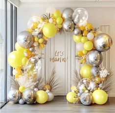 an arch made out of balloons and pine cones with the words let's mama on it