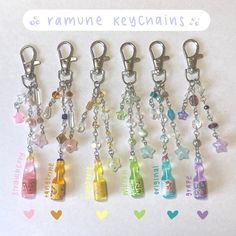 six keychains with different colored bottles and charms attached to them, on a white background