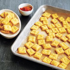 an advertisement for crackers and sauces on a table with other items in bowls