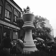 black and white photograph of people standing in front of a building with an outdoor fountain