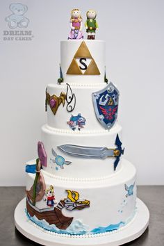 a three tiered white cake with cartoon characters on the top and bottom layer,