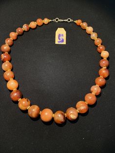 The beautiful orange color carnelian beads necklace from Himalaya Nepal This beads were used in prayer malas and used as jewelry and amulets in ancient times very smooth and shinny surface of this beads because of passage of time and usage of this beads in prayers mala and in necklace The age of this beads are more than 1000 years small size gold color brass beads are used as spacers in the necklace we provide fast and free shipping service to our customers by which can get the items by maximum Traditional Orange Carnelian Beaded Necklace, Orange Carnelian Necklace In Spiritual Style, Artisan Orange Carnelian Beaded Necklaces, Orange Beaded Necklaces With Natural Stones In Spiritual Style, Orange Carnelian Polished Beads Necklace, Spiritual Orange Beaded Necklaces With Oval Beads, Orange Spiritual Beaded Necklace With Natural Stones, Spiritual Orange Beaded Necklace With Oval Beads, Spiritual Orange Beaded Necklace With Natural Stones