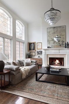 a living room filled with furniture and a fire place in the middle of it's wall