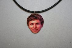 a man's face is shown on a necklace