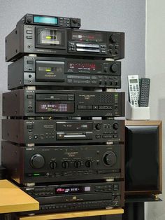 a stack of stereo equipment sitting on top of a wooden table