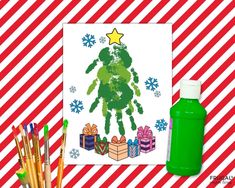 a christmas tree made out of handprints next to markers and pencils