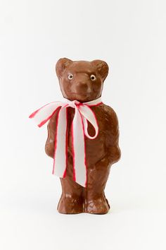 a chocolate bear with a red and white ribbon around it's neck on a white background