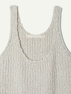 the back of a tank top that is knitted in white and has an open neckline