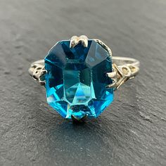 Vintage Blue Cubic Zirconia Sterling Silver Statement Ring, UK Size K1/2, US Size 5 1/4, EU Size 50 1/4, Stamped Silver, Front Max Width 12.6mm, Weight 2.42 Grams, Lovely Condition Vintage Blue Diamond Cut Jewelry, Vintage Blue Jewelry With Diamond Cut, Blue Vintage Jewelry With Diamond Cut, Blue Faceted Sapphire Ring For Wedding, Vintage Blue Ring With Diamond Cut, Blue Aquamarine Diamond Cut Rings, Blue Faceted Topaz Ring For Anniversary, Handmade Blue Crystal Ring For Wedding, Anniversary Blue Faceted Topaz Ring