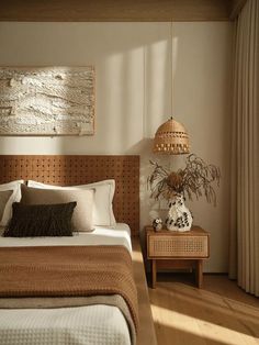 a bed sitting in a bedroom next to a wooden table with a plant on it