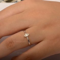 a woman's hand with a diamond ring on it