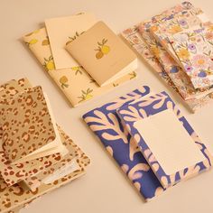 five notebooks lined up on top of each other with paper attached to the covers