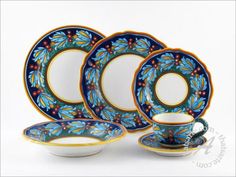 a blue and yellow dinner set with matching saucers