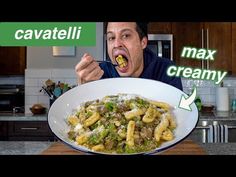 a man is eating pasta with broccoli and cheese in his mouth while looking at the camera