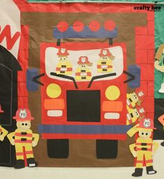 a fire truck made out of construction paper and cutout people standing in front of it