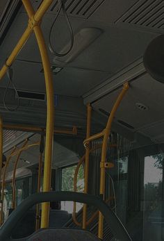 the interior of a public transit bus with yellow metal railings and seats on both sides