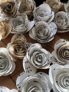 many paper flowers are arranged on top of sheet music score sheets in the shape of roses