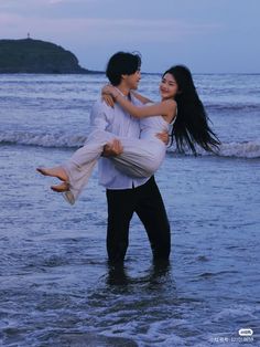 a man carrying a woman on his back in the water at sunset by the beach