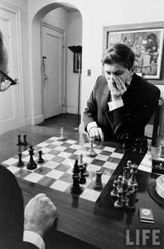 two men are playing chess in the living room