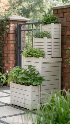 three white planters with plants growing in them