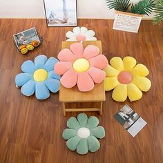 four flower shaped cushions sitting on top of a wooden table next to a magazine rack