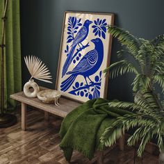 a blue and white bird is sitting on a bench in front of a green plant