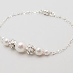 Elegant White Pearl Bracelet With Adjustable Chain, White Pearl Embellished Bracelet, Elegant White Crystal Bracelet For Anniversary, Elegant White Sterling Silver Crystal Bracelet, Elegant Silver Crystal Bracelet With Pearl Charm, White Crystal Jewelry With Pearl Charm, Elegant White Crystal Bracelets, Elegant White Pearl Crystal Bracelet, Elegant Beaded Pearl White Crystal Bracelet