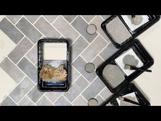 three black trays filled with food sitting on top of a tiled floor next to each other