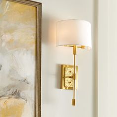 a wall light next to a painting on the wall