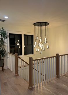 a chandelier hanging from the side of a stair case