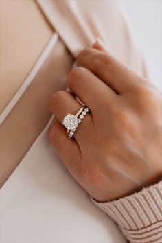 a woman's hand wearing a gold and diamond ring