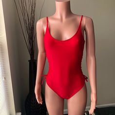 Red One Piece Suit. The Sides Tie Up And Can Be Adjusted To Fit Size Or Show More Skin. The Straps Are Adjustable. It Is Fully Lined And Not See Through. Never Worn Or Washed. Still Has Hygienic Liner. Red Stretch Backless Swimwear, Red Stretch Swimwear With Lined Body, Red Stretch Lined Swimwear, Red Sleeveless Bodysuit For Beachwear, Sleeveless Red Bodysuit For Beachwear, Red Stretch Bodysuit For Poolside, Red Sleeveless Swimwear For Party, Red Sleeveless Bodysuit For Beach Season, Red Sleeveless Party Swimwear