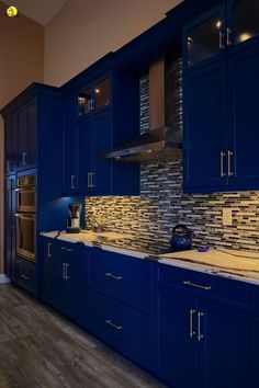 a kitchen with blue cabinets and tile backsplash