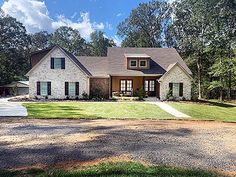 a large house in the middle of a wooded area with lots of grass and trees