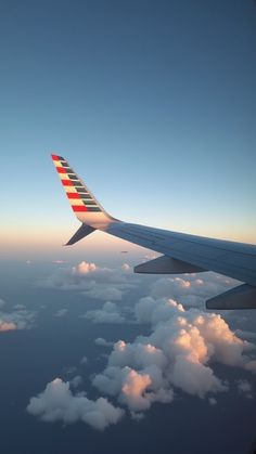 the wing of an airplane flying over clouds