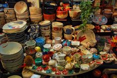 a table topped with lots of different types of plates and bowls on top of each other