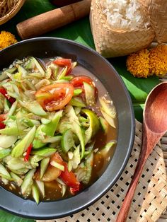 a bowl filled with vegetables and sauce on top of a table next to other foods