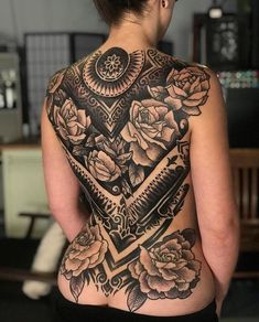 the back of a woman's body with tattoos on her upper and lower half