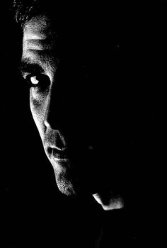 black and white photograph of a man's face in the dark