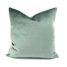 a green velvet pillow on a white background