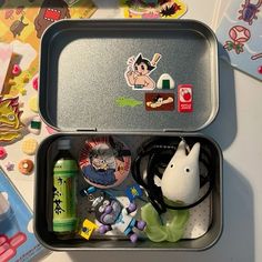 two tins filled with toys on top of a table