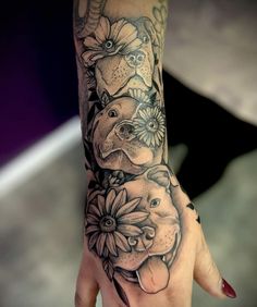 a woman's hand with an elephant and flowers tattoo on it