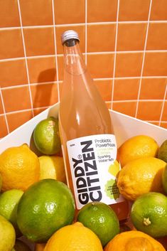 a bottle of glyzer surrounded by lemons and limes