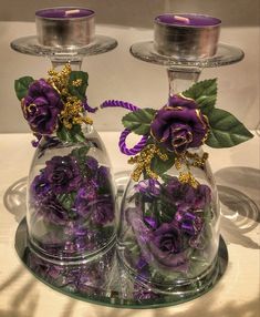 two glass vases with purple flowers in them