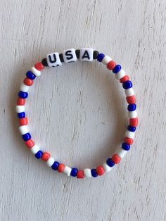 This bracelet is the perfect addition to show your American spirit! The beads are strung on one of the strongest white cords! The beads are glass with the black beads surrounding the words USA being made out of black matte. This bracelet would make a great gift for both male or female!  This bracelet comes in 5 inches; 5 1/2 inches; 6 inches; 6 1/2 inches; 7 inches; 7 1/2 inches; 8 inches; 8 1/2 inches. Please specify what size you would like. Patriotic White Stretch Bracelet With Round Beads, Patriotic White Stretch Bracelet, Adjustable White Patriotic Beaded Bracelets, Clay Bracelet, Beads Bracelet Design, American Spirit, Black Matte, Blue Bracelet, Bracelet Patterns