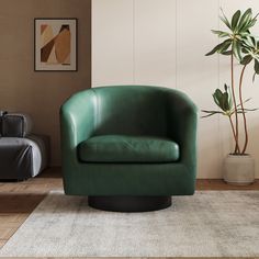 a green chair sitting on top of a wooden floor next to a potted plant