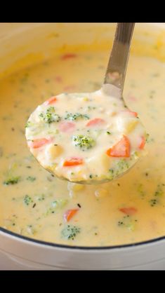 a ladle full of soup with broccoli and carrots