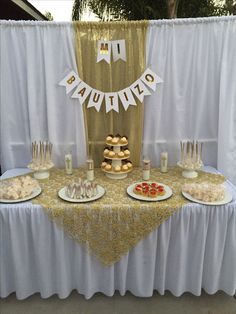 a table topped with desserts and pastries on top of a white table cloth