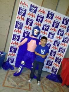 two young boys standing next to each other in front of a purple and pink costume